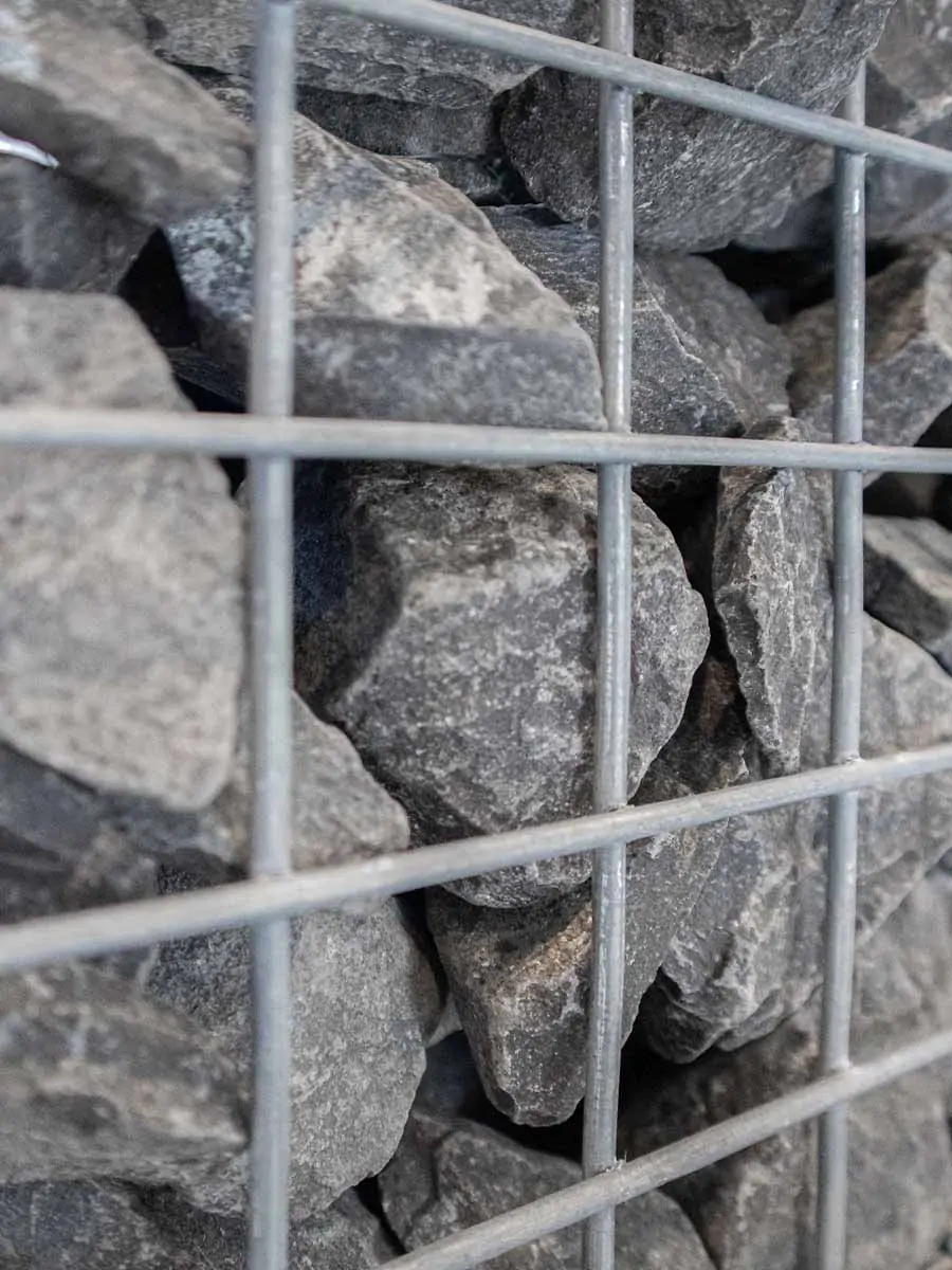 Grote Ardenner-breukstenen in een metalen steenkorf